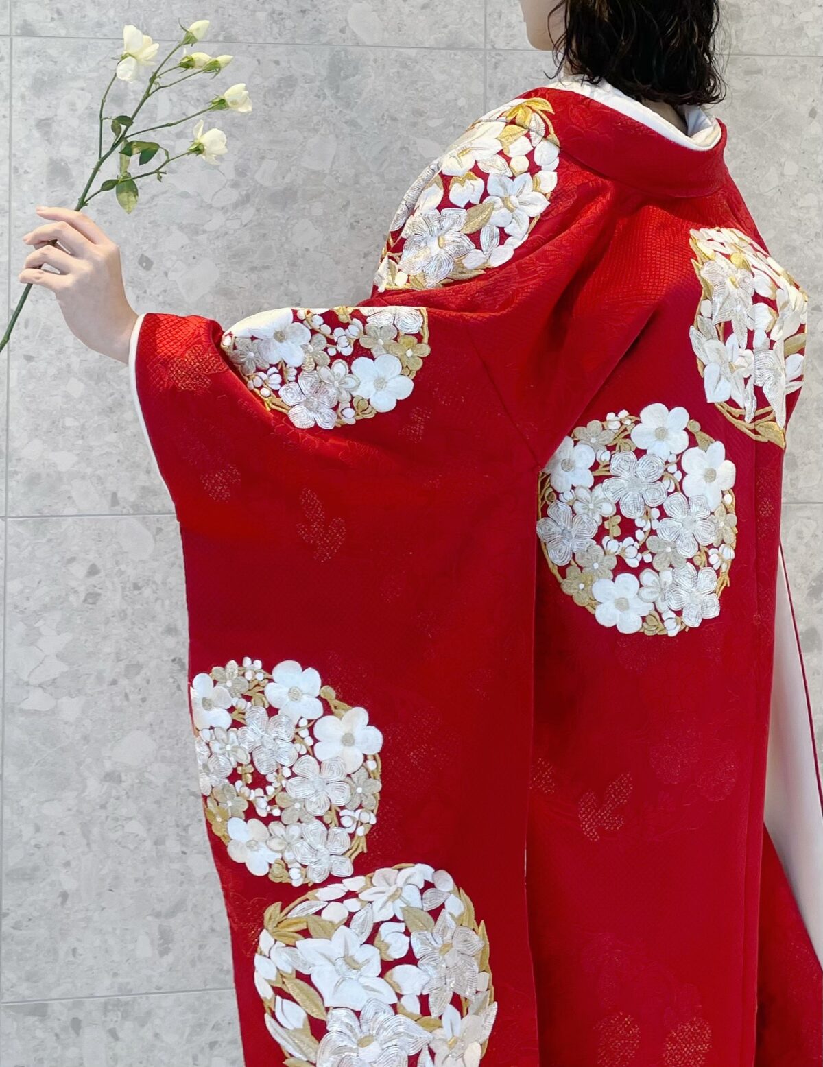 華やかな花丸紋が印象的な赤の色打掛を身に纏い凛とした白のお花を合わせることで凛とした印象を叶えるコーディネートのご紹介